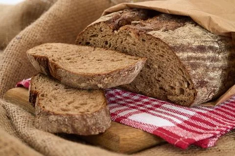 Rye bread sliced or cut on red towel and wooden board Stock Photos