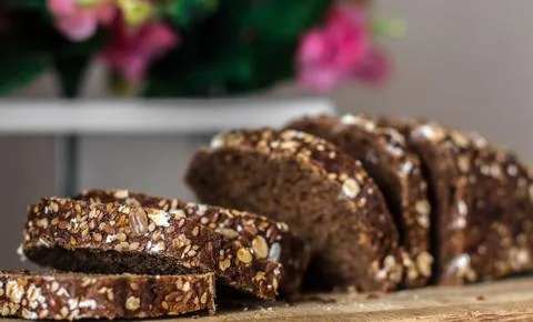 Rye bread with sliced ??seeds. Sliced ??black bread on the old wooden plank o Stock Photos