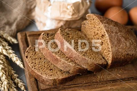 Rye bread sliced on wooden cutting board Stock Photos