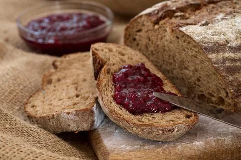 Rye bread slices spread with fruit jam and knife top on bread Stock Photos