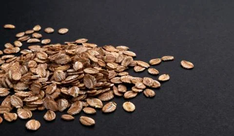 Rye flakes on black background with copy space Foto stock