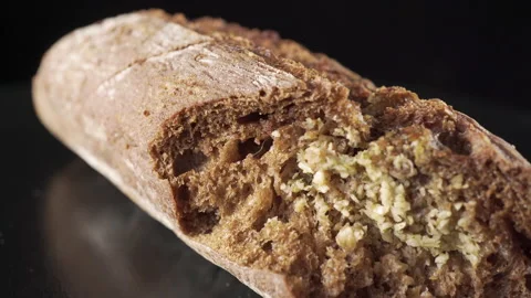 Rye flour bread with chopped garlic on black background Stock Footage 136135732