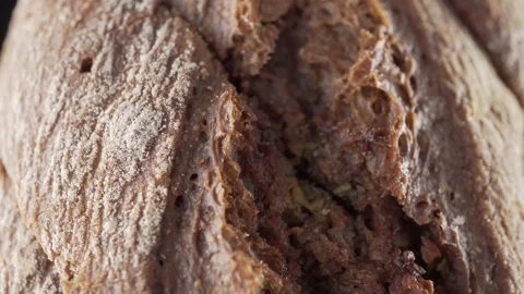 Rye flour bread with chopped garlic on black background Stock Footage 136135958