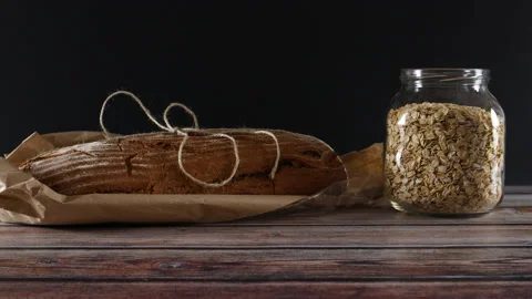 Rye organic and healthy bread on the table with oatmeal in jar. 스톡 동영상 137611752
