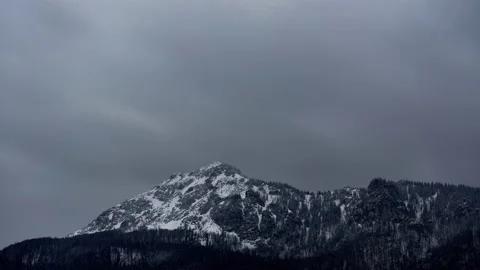 RZSTC biela. 6.3Dense clouds over a rocky snowy peak. Windy winter weather. Video stock 152447890