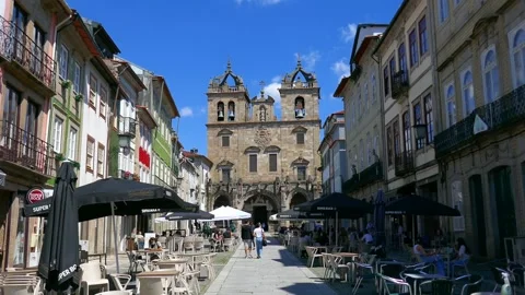 S de Braga Cathedral facade with people walking and shops Stock Footage 156764931
