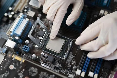 S hand insert processor cpu chip in the socket of motherboard, computer assembly Stock Photos