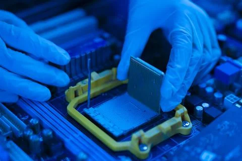 S hand insert processor cpu chip in the socket of motherboard, computer assembly Foto stock