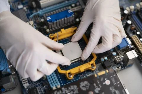 S hand insert processor cpu chip in the socket of motherboard, computer assembly Stock Photos