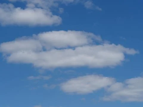 S white fluffy clouds in blue sky Stock Photos