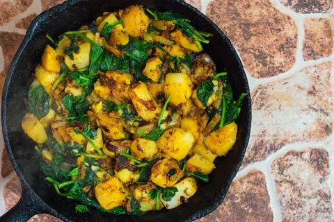 Saag Aloo, Indian style spinach and potatoes in cast iron pan Stock Photos