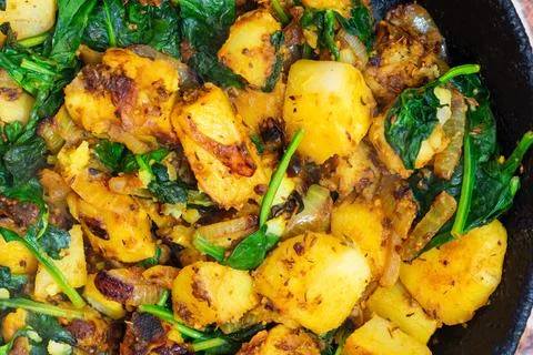 Saag Aloo, Indian style spinach and potatoes in cast iron pan Stock Photos