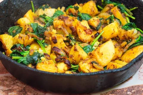 Saag Aloo, Indian style spinach and potatoes in cast iron pan Stock Photos