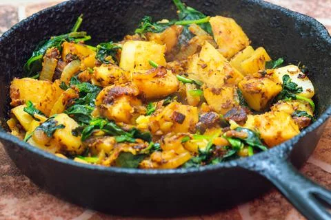 Saag Aloo, Indian style spinach and potatoes in cast iron pan Stock Photos
