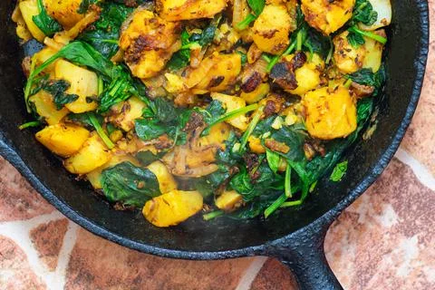Saag Aloo, Indian style spinach and potatoes in cast iron pan Stock Photos
