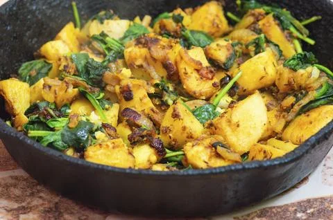 Saag Aloo, Indian style spinach and potato dish in cast iron pan Stock Photos
