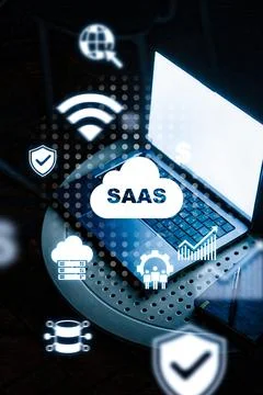 Saas concepts shown on laptop screen with various icons in a dark workspace Stock Photos