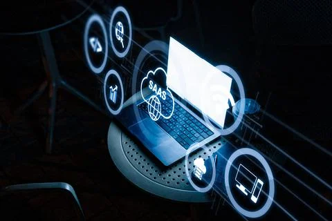 Saas software icon displayed on laptop screen during night setting at outdoor Stock Photos