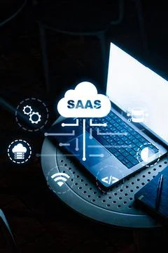 Saas software icon over laptop and notes on round table in office setting at Stock Photos