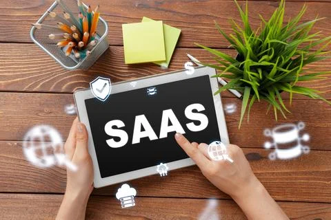 Saas software service displayed on a tablet with icons and a workspace setting Stock Photos