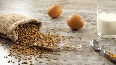 Sack of wheat, milk, eggs, and fresh bread on a rustic wooden table. Countryside Stock-Footage 70875873
