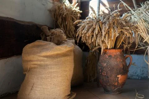 Sacks of ground grains of bread stands next to a jug of bread sticks Stock Photos