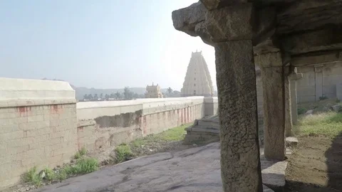 Sacred Hindu temple complex with pillars and distant Virupaksha temple Stock Footage 83469412