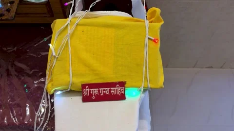 Sacred scripture of sikhism the guru granth sahib display with yellow drape and Видео 321443047