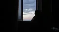 sad and lonely woman looks out the window HD Footage