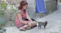 sad and lonely young woman sitting on the street stroking a kitten HD Footage