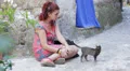 sad and lonely young woman sitting on the street stroking a kitten HD Footage