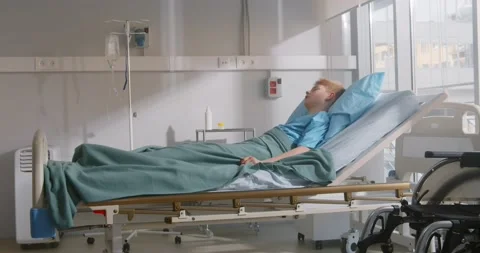 Sad and weak sick boy lying alone in hospital bed Vidéo 154147413
