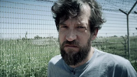Sad angry man in prison looking camera feeling depressed Vidéo 107467346