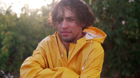 Sad arabic man under summer rain. Emotional guy wear yellow raincoat wet in the Stock Footage 252670936