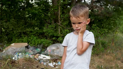 A sad boy against the backdrop of garbage. Save the nature. Stop polluting the Stock Footage 201089559