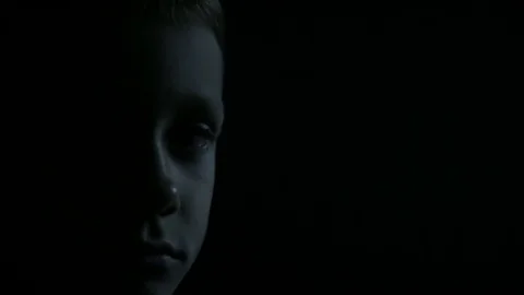 Sad boy close-up: half face in the dark Stock Footage