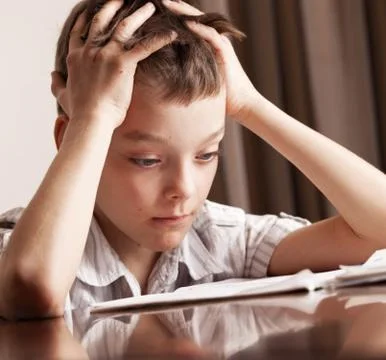 Sad boy doing homework Stock Photos