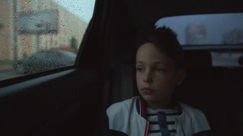 Sad boy inside a car in rainy weather Stock Footage 91495425