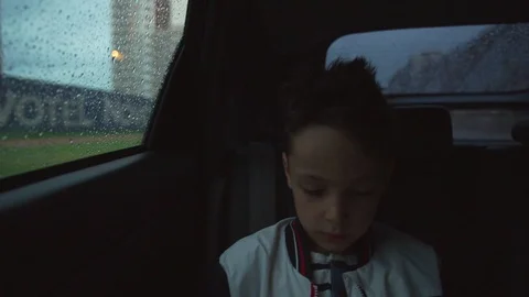 Sad boy inside a car in rainy weather Видео 91495889