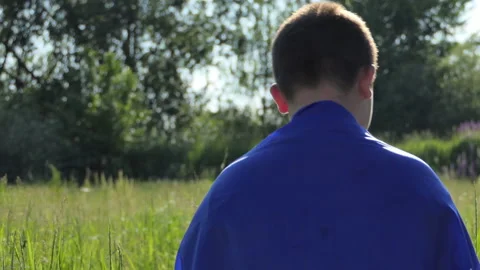Sad boy looking at the camera with the national flag of Ukraine outdoors in a Stock Footage 197569546