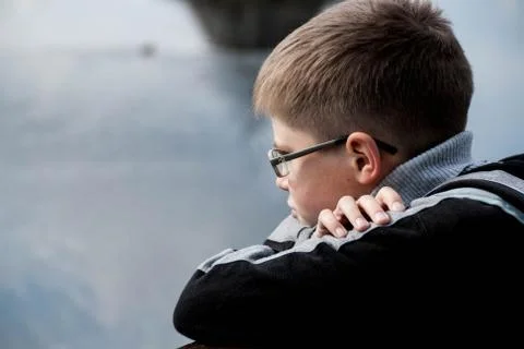 Sad boy looking at the river Stock Photos