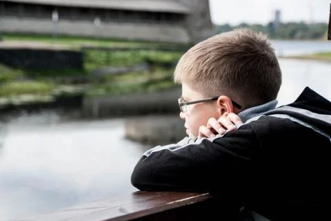 Sad boy looking at the river Stock Photos