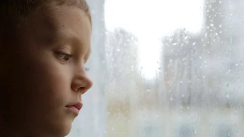 Sad boy looks out the window in rainy weather Stock-Footage 81067133