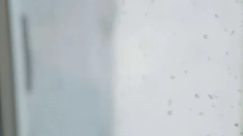 Sad boy looks out the window in rainy weather Vidéo 81070932