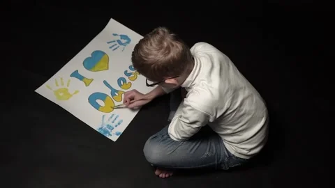 Sad boy sitting drawing poster Stock Footage 175996484