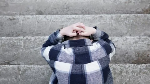 Sad boy sitting outside in a bad mood after school. Childhood depression. Stock Footage 313063614