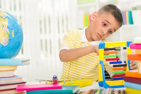 Sad boy studyng for written assignment Stock Photos