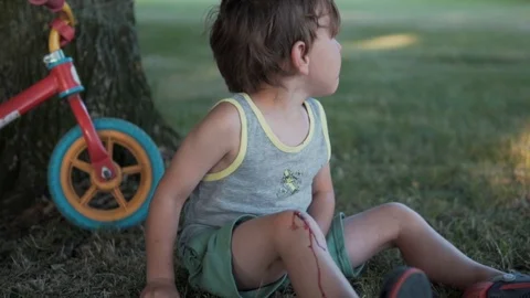 Sad boy with wound on knee Stock Footage 95085254