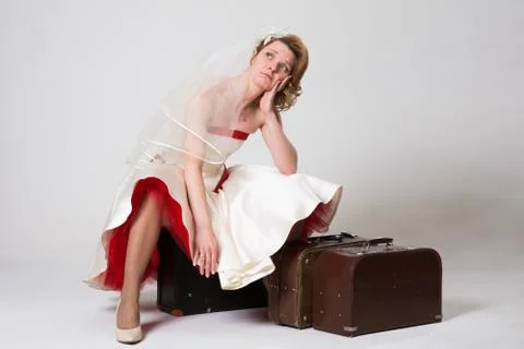 Sad bride with suitcases on white background in studio Stock Photos