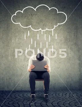 Sad business man sitting on a chair with laptop looking down with a rain clou Stock Photos